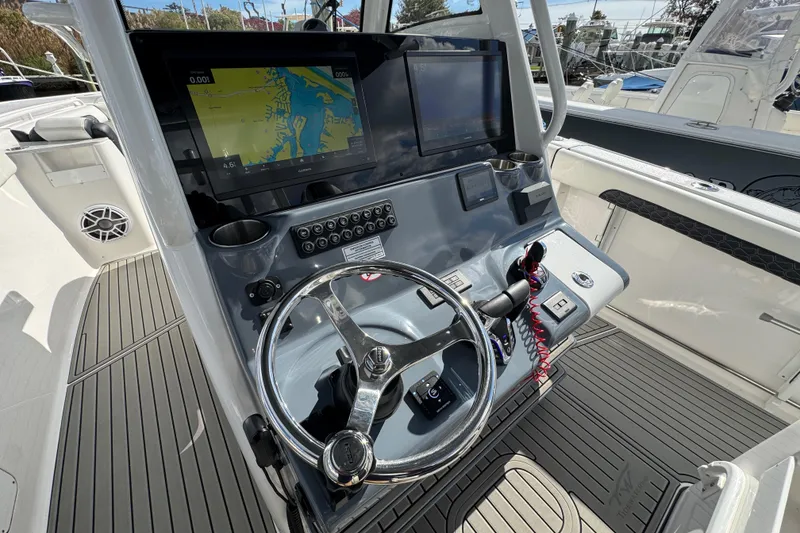 Slide: The Image of 2025 Tidewater 302 CC Adventure boat dashboard with navigation screens and steering wheel. - 40