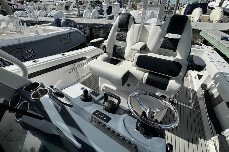 Slide: The Image of 2025 Tidewater 302 CC Adventure boat interior with dual seats and steering wheel. - 53