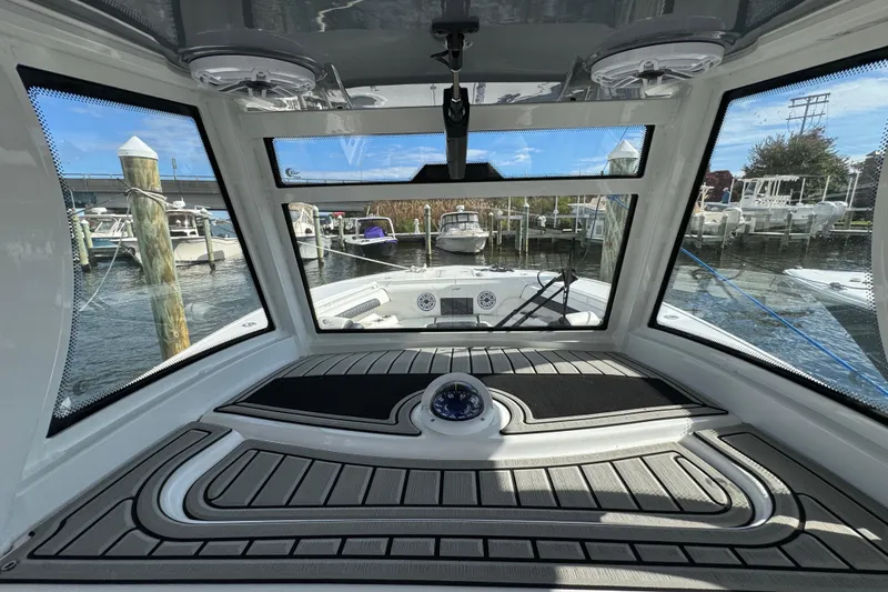 Slide: The Image of 2025 Tidewater 302 CC Adventure boat interior with marina view through windshield. - 54