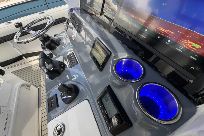 Slide: The Image of 2025 Tidewater 302 CC Adventure boat dashboard with advanced controls and illuminated cup holders. - 55