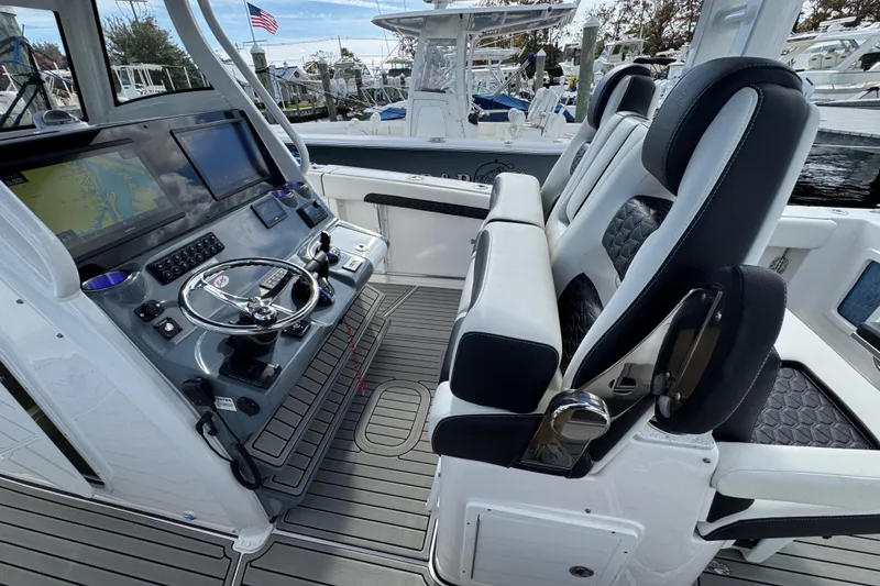 Slide: The Image of 2025 Tidewater 302 CC Adventure boat cockpit with dual seats and advanced navigation system. - 58