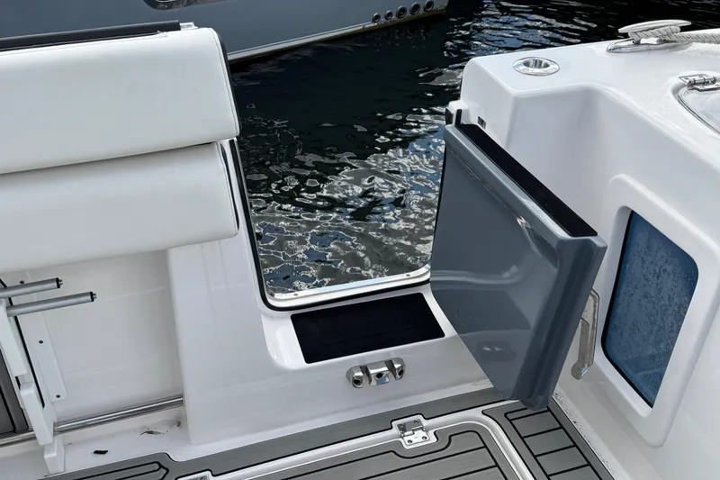 Slide: The Image of 2025 Tidewater 302 CC Adventure boat with open side door, docked on water. - 62
