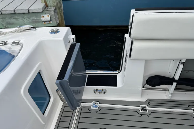 Slide: The Image of 2025 Tidewater 302 CC Adventure boat with open side door and cushioned seating. - 64