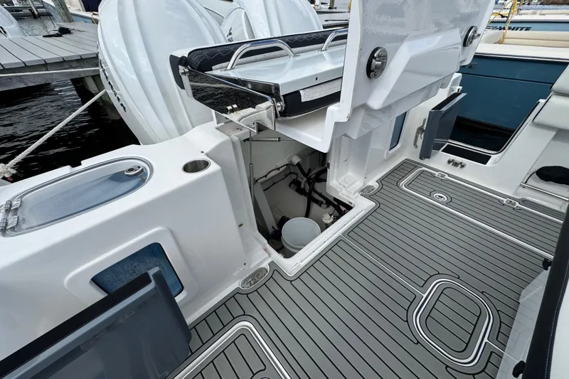 Slide: The Image of 2025 Tidewater 302 CC Adventure boat interior with open storage compartment and sleek deck design. - 66