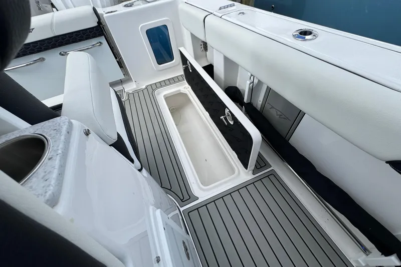 Slide: The Image of 2025 Tidewater 302 CC Adventure boat interior with open storage compartment and sleek design. - 68