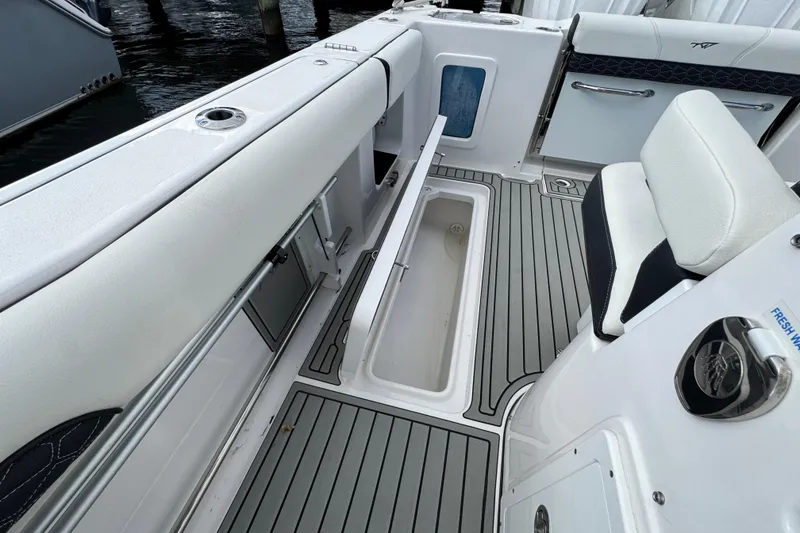 Slide: The Image of 2025 Tidewater 302 CC Adventure boat interior with open storage compartment and seating. - 69