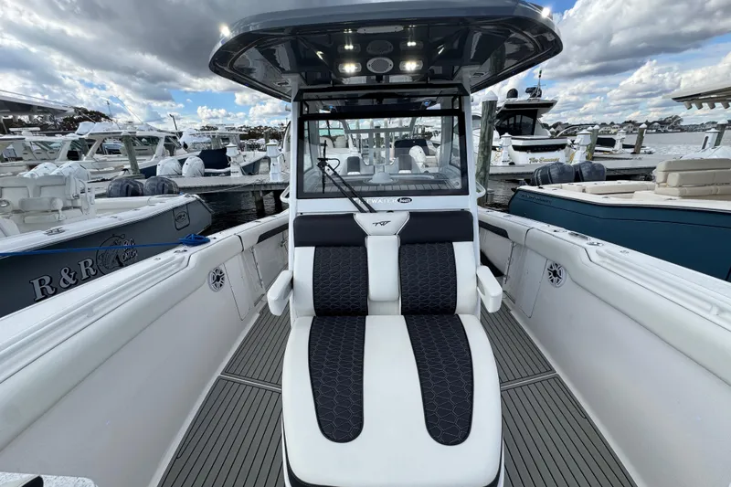 Slide: The Image of 2025 Tidewater 302 CC Adventure boat interior at marina, featuring sleek seating and modern design. - 73