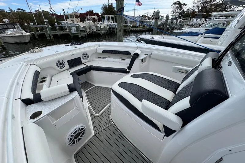 Slide: The Image of 2025 Tidewater 302 CC Adventure boat interior with stylish seating and modern amenities at a marina. - 76