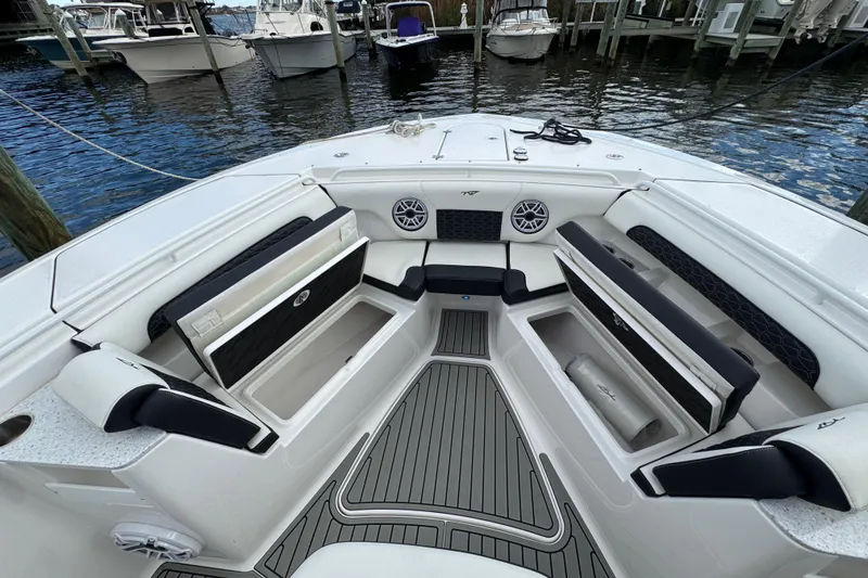 Slide: The Image of 2025 Tidewater 302 CC Adventure boat interior with seating and storage, docked by the water. - 84