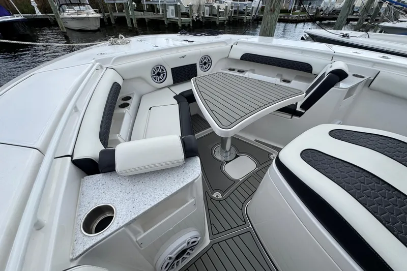 Slide: The Image of 2025 Tidewater 302 CC Adventure boat interior with seating and table, docked at marina. - 95