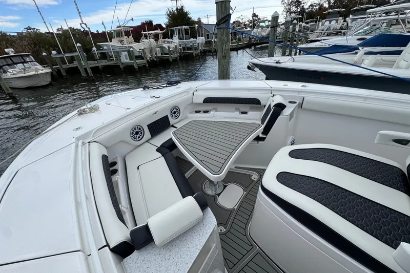 Slide: The Image of 2025 Tidewater 302 CC Adventure boat interior with seating and table at marina. - 96