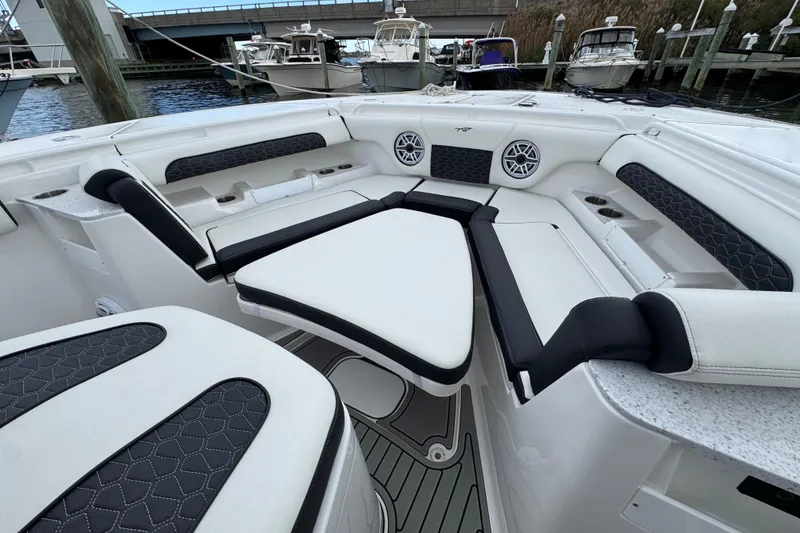 Slide: The Image of 2025 Tidewater 302 CC Adventure boat interior with cushioned seating and speakers. - 98