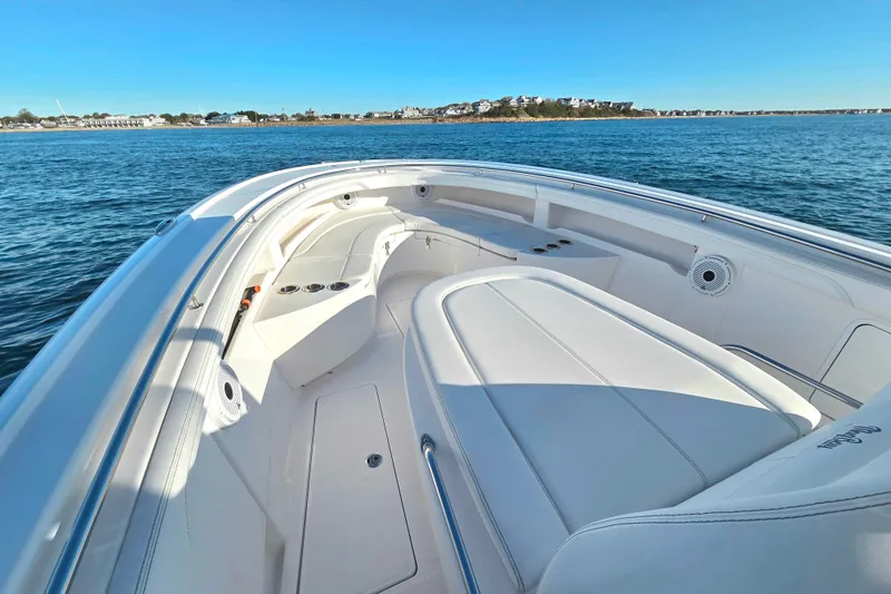 Slide: The Image of 2022 Mag Bay 33 CC boat interior with white seating, on calm blue water. - 15