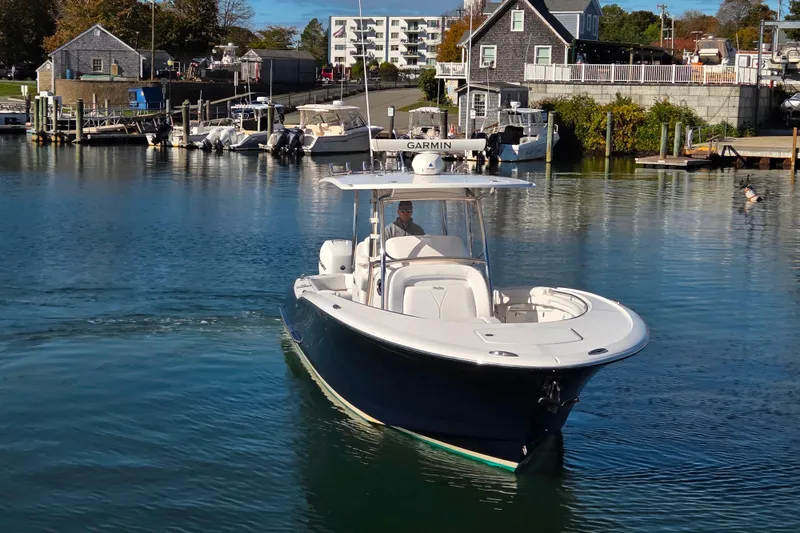 Slide: The Image of 2022 Mag Bay 33 CC boat cruising in a scenic harbor setting. - 18