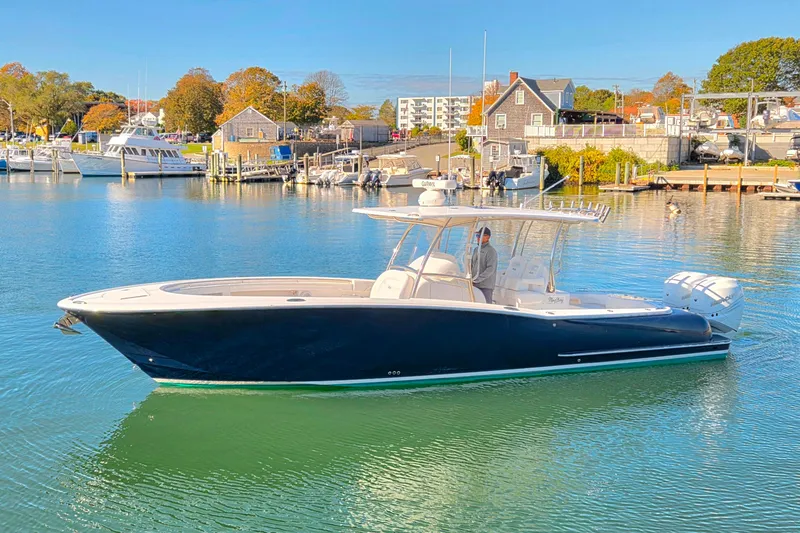 Slide: The Image of 2022 Mag Bay 33 CC boat cruising in a scenic marina setting. - 19