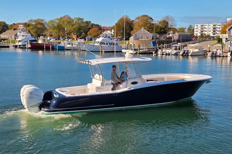 Slide: The Image of 2022 Mag Bay 33 CC boat cruising in a scenic marina with clear blue water. - 2