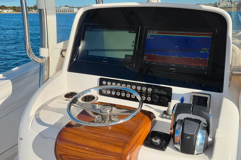 Slide: The Image of 2022 Mag Bay 33 CC boat dashboard with navigation screens and controls. - 6