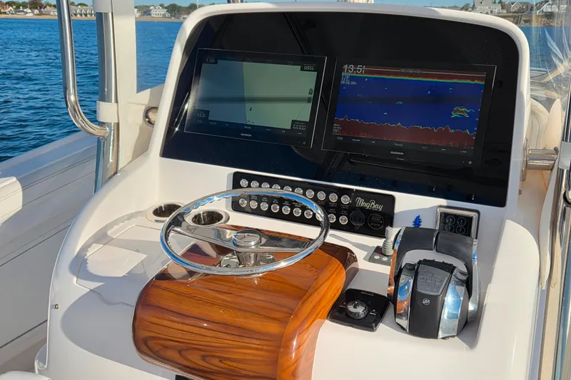 Slide: The Image of 2022 Mag Bay 33 CC boat dashboard with navigation screens and controls. - 7