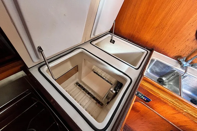 Slide: The Image of Interior of 1986 Beneteau First 42 yacht showing open storage compartments and sink. - 11