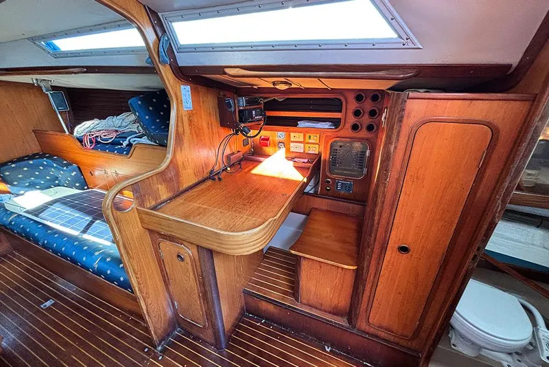 Slide: The Image of 1986 Beneteau First 42 yacht interior with wooden navigation station and seating area. - 12