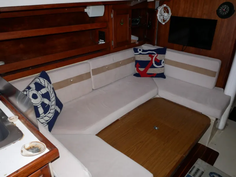 Slide: The Image of Interior of 1982 Catalina 38 sailboat with cozy seating and nautical-themed pillows. - 19