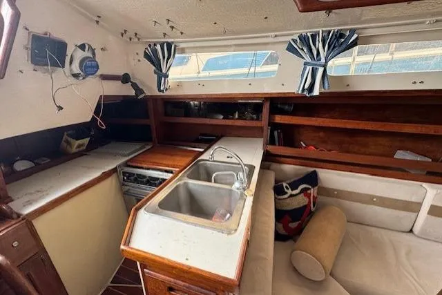 Slide: The Image of Interior of 1982 Catalina 38 sailboat with kitchen, sink, and seating area. - 23
