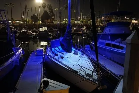 Slide: The Image of 1982 Catalina 38 sailboat docked at night, illuminated by blue lights. - 35