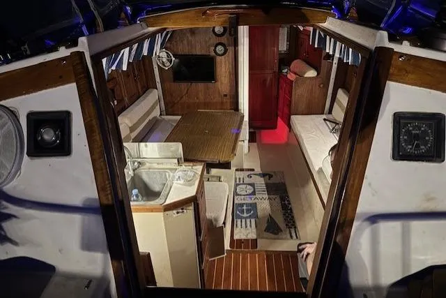 Slide: The Image of Interior of 1982 Catalina 38 sailboat with cozy seating, table, and nautical decor. - 38