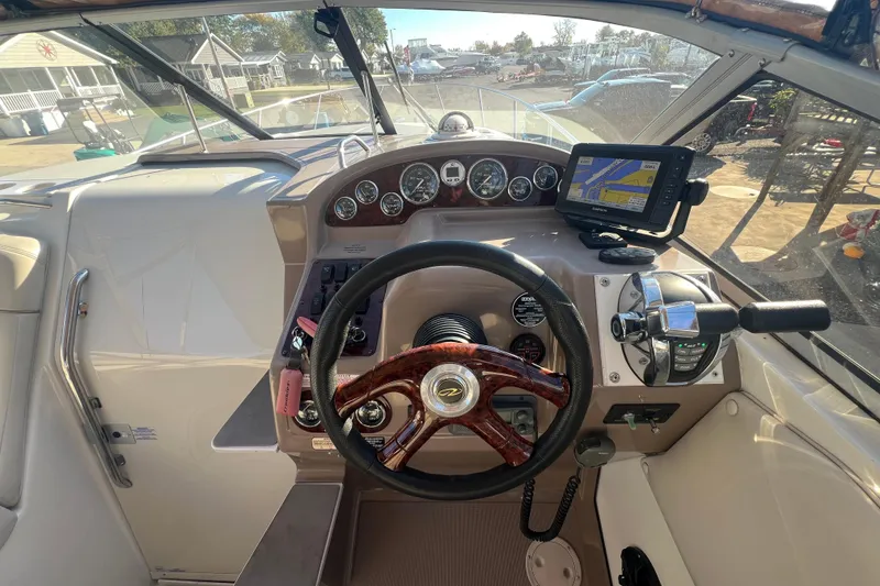 Slide: The Image of 2002 Regal Commodore 2765 boat dashboard with steering wheel and navigation system. - 10