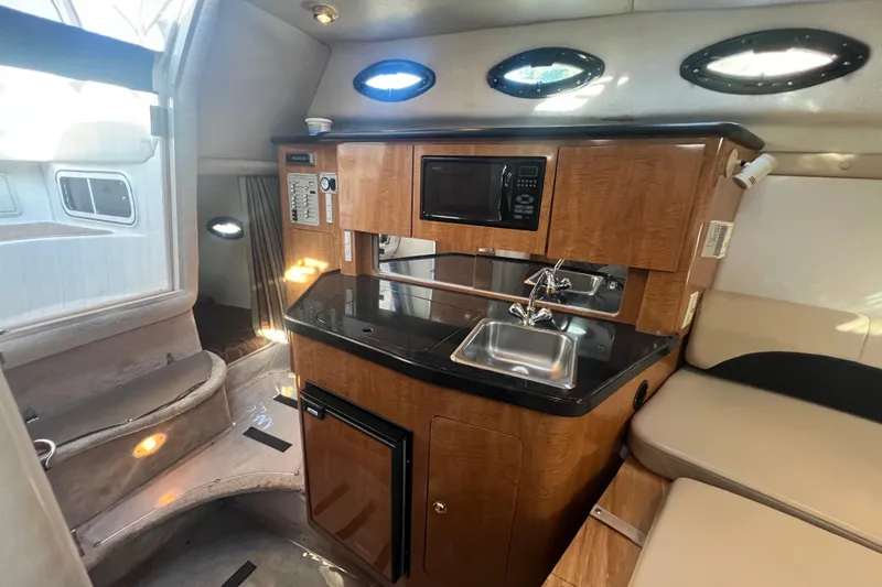 Slide: The Image of 2002 Regal Commodore 2765 boat interior with kitchenette, sink, and seating area. - 13