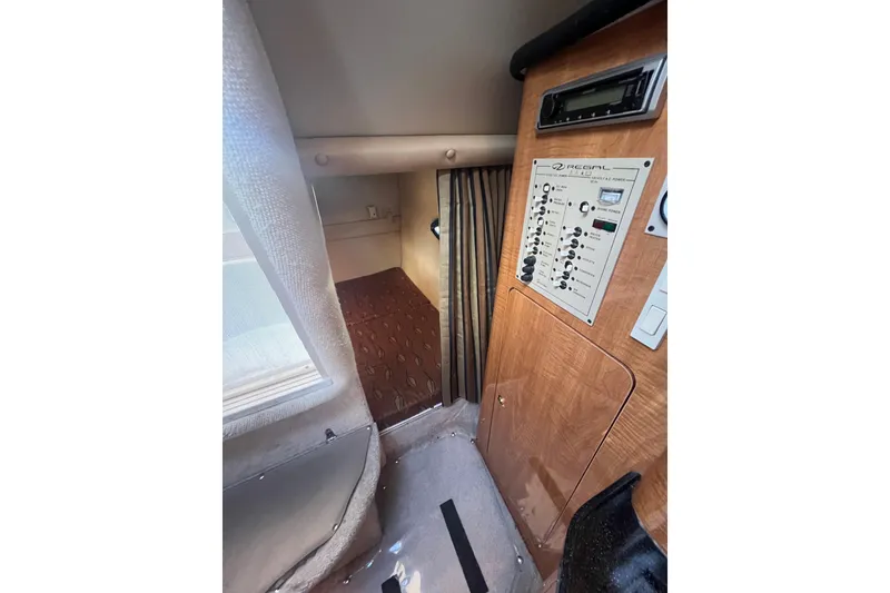 Slide: The Image of 2002 Regal Commodore 2765 cabin interior with control panel and cozy sleeping area. - 14