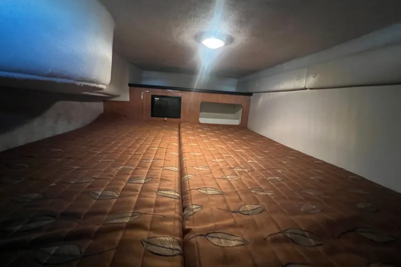 Slide: The Image of Cozy cabin interior of 2002 Regal Commodore 2765 with patterned bedding and soft lighting. - 15