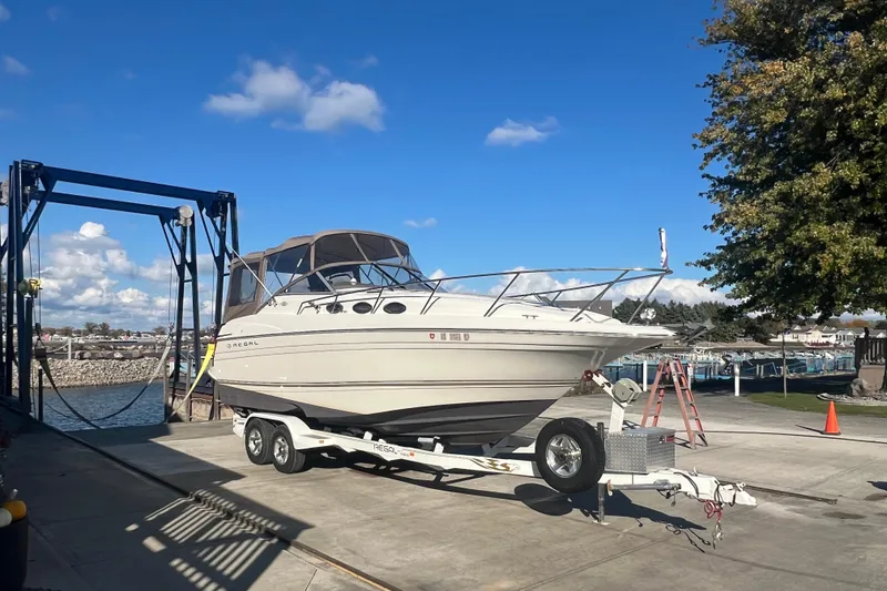 Slide: The Image of 2002 Regal Commodore 2765 boat on trailer at marina under blue sky. - 2