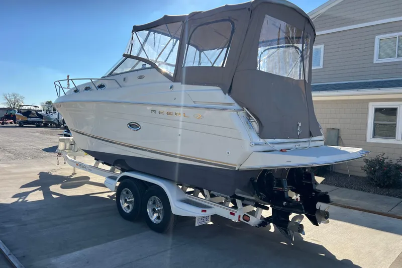 Slide: The Image of 2002 Regal Commodore 2765 boat on trailer, parked outdoors, with protective cover. - 4