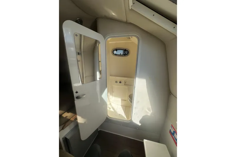 Slide: The Image of Interior of 2001 Boston Whaler 28 Outrage boat bathroom with porthole window. - 22