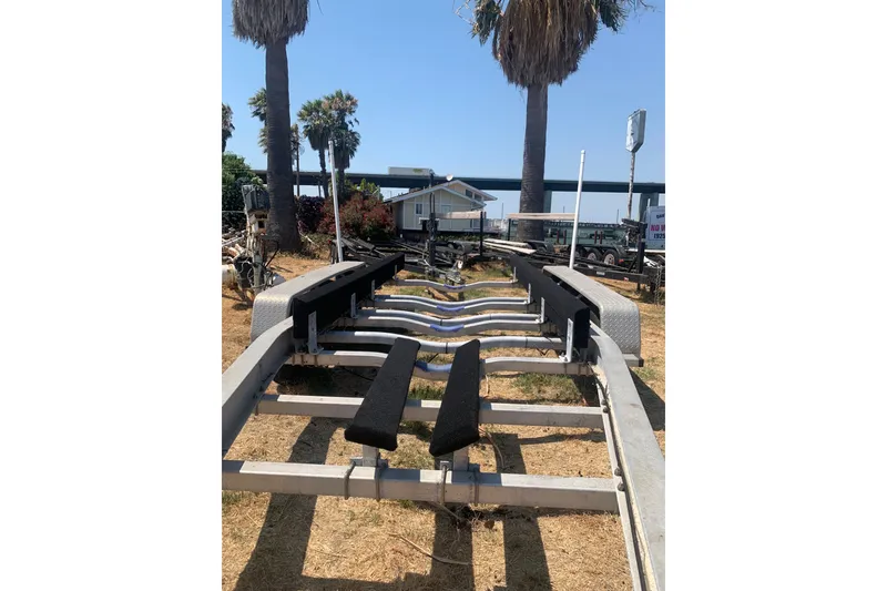 Slide: The Image of Empty boat trailer for 2001 Boston Whaler 28 Outrage, parked outdoors near palm trees. - 29