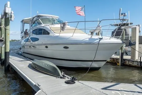 The Image of 2005 Cruiser Yachts 405 EXPRESS docked, featuring sleek design and American flag. - 0