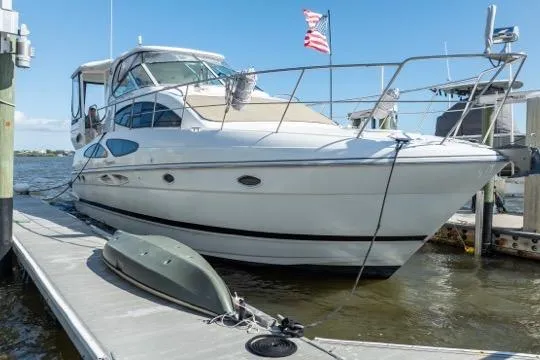 Slide: The Image of 2005 Cruiser Yachts 405 EXPRESS docked, featuring sleek design and American flag. - 104