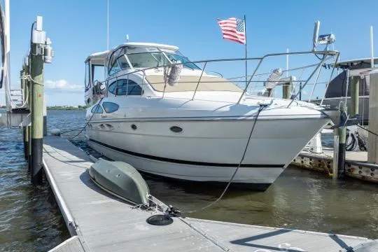 Slide: The Image of 2005 Cruiser Yachts 405 EXPRESS docked, featuring sleek design and American flag. - 105
