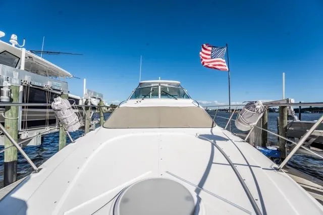 Slide: The Image of 2005 Cruiser Yachts 405 EXPRESS docked, American flag waving, clear blue sky. - 11