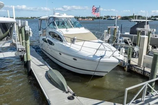 Slide: The Image of 2005 Cruiser Yachts 405 EXPRESS docked at marina with American flag in background. - 113
