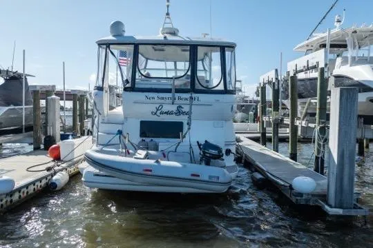 Slide: The Image of 2005 Cruiser Yachts 405 EXPRESS docked at marina, rear view with dinghy attached. - 117