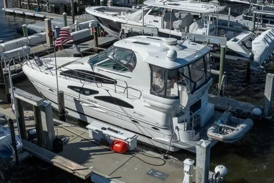 Slide: The Image of 2005 Cruiser Yachts 405 EXPRESS docked at marina, featuring sleek design and American flag. - 119