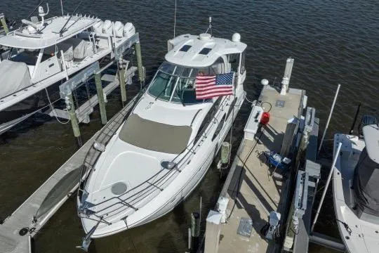 Slide: The Image of 2005 Cruiser Yachts 405 EXPRESS docked, displaying an American flag, surrounded by watercraft. - 121