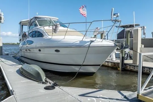 Slide: The Image of 2005 Cruiser Yachts 405 EXPRESS docked, featuring sleek design and American flag. - 2