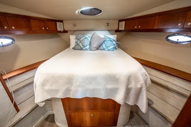 Slide: The Image of Luxurious cabin interior of 2005 Cruiser Yachts 405 EXPRESS with cozy bed and elegant wood finish. - 39