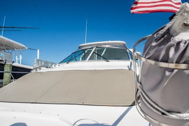 Slide: The Image of 2005 Cruiser Yachts 405 EXPRESS docked, featuring a covered windshield and American flag. - 47
