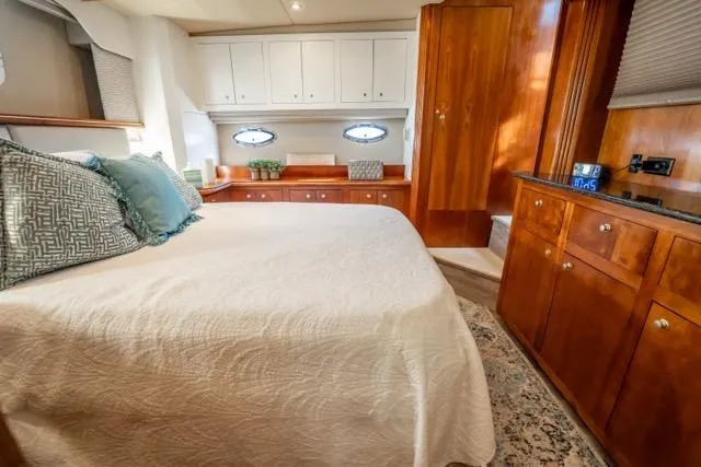 Slide: The Image of Luxurious 2005 Cruiser Yachts 405 EXPRESS cabin with elegant wood finishes and cozy bedding. - 53