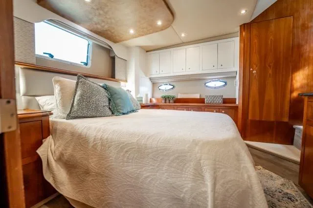 Slide: The Image of Luxurious 2005 Cruiser Yachts 405 EXPRESS cabin with elegant bedding and wooden cabinetry. - 62