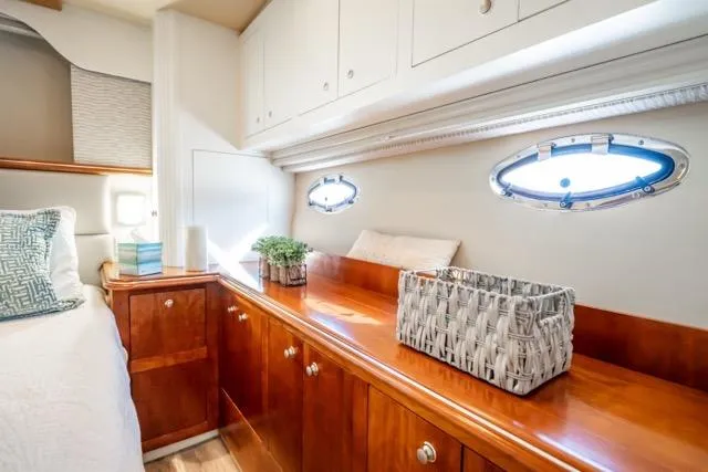 Slide: The Image of Luxurious 2005 Cruiser Yachts 405 EXPRESS cabin interior with elegant wood cabinetry and porthole windows. - 63